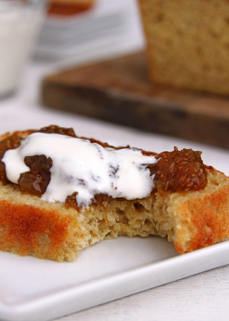 Fatia de pão de forma com geleia de figo e creme de leite em um prato branco