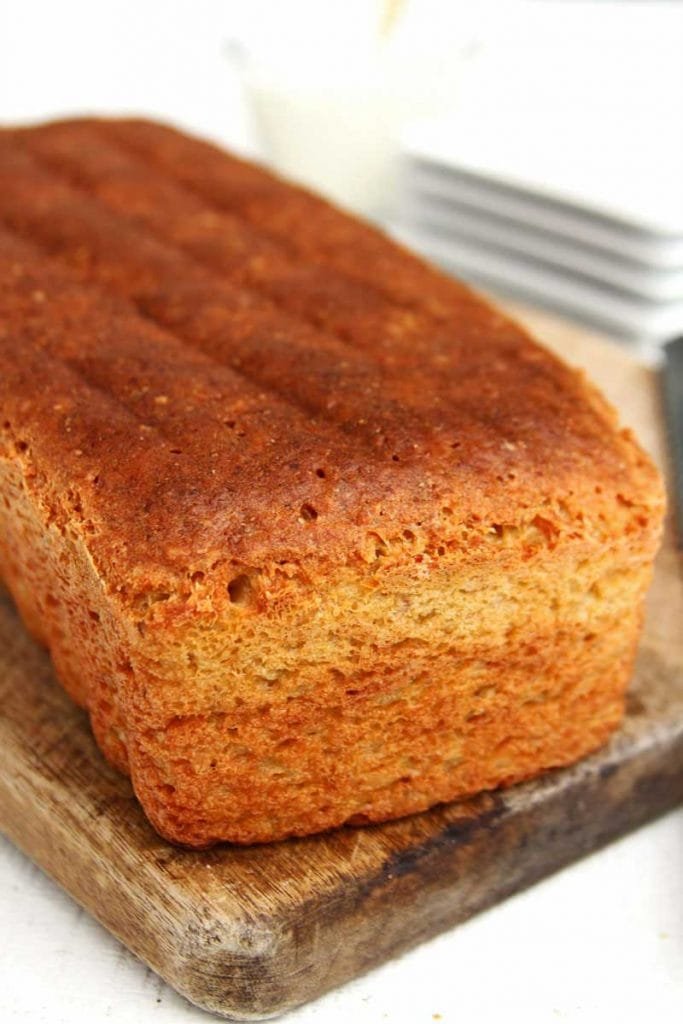 Pão de forma sobre tábua marrom em uma mesa branca