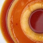 Pudim com calda de caramelo sobre prato branco