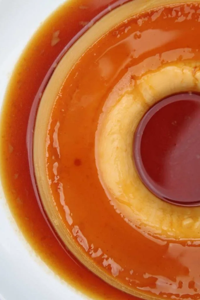 Pudim com calda de caramelo sobre prato branco