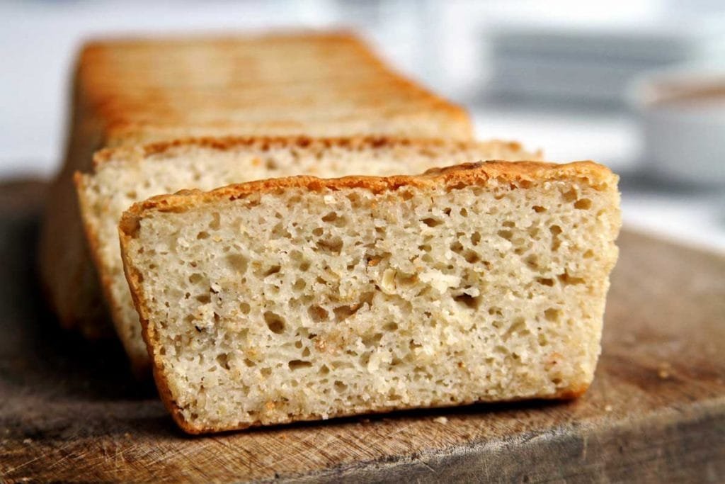 Pão de forma fatiado sobre tábua de madeira