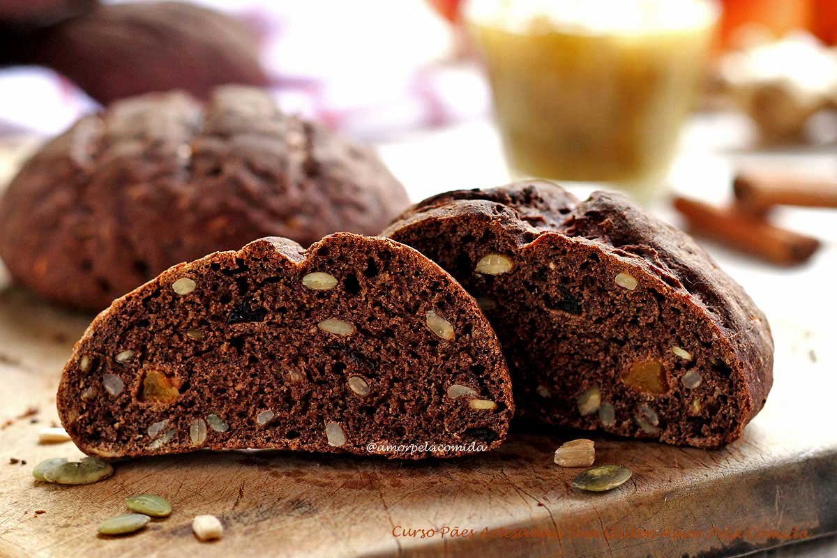 Pão preto com sementes e frutas secas sobre tábua de madeira