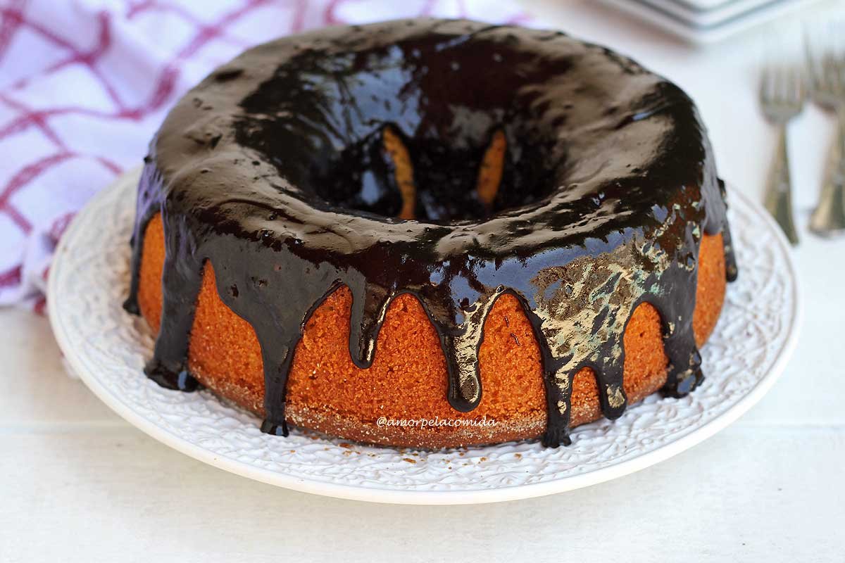 Bolo de cenoura com cobertura de chocolate sobre prato branco