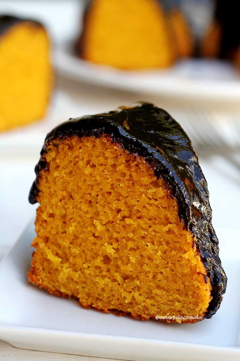 Fatia de bolo de cenoura com calda de chocolate sobre prato branco