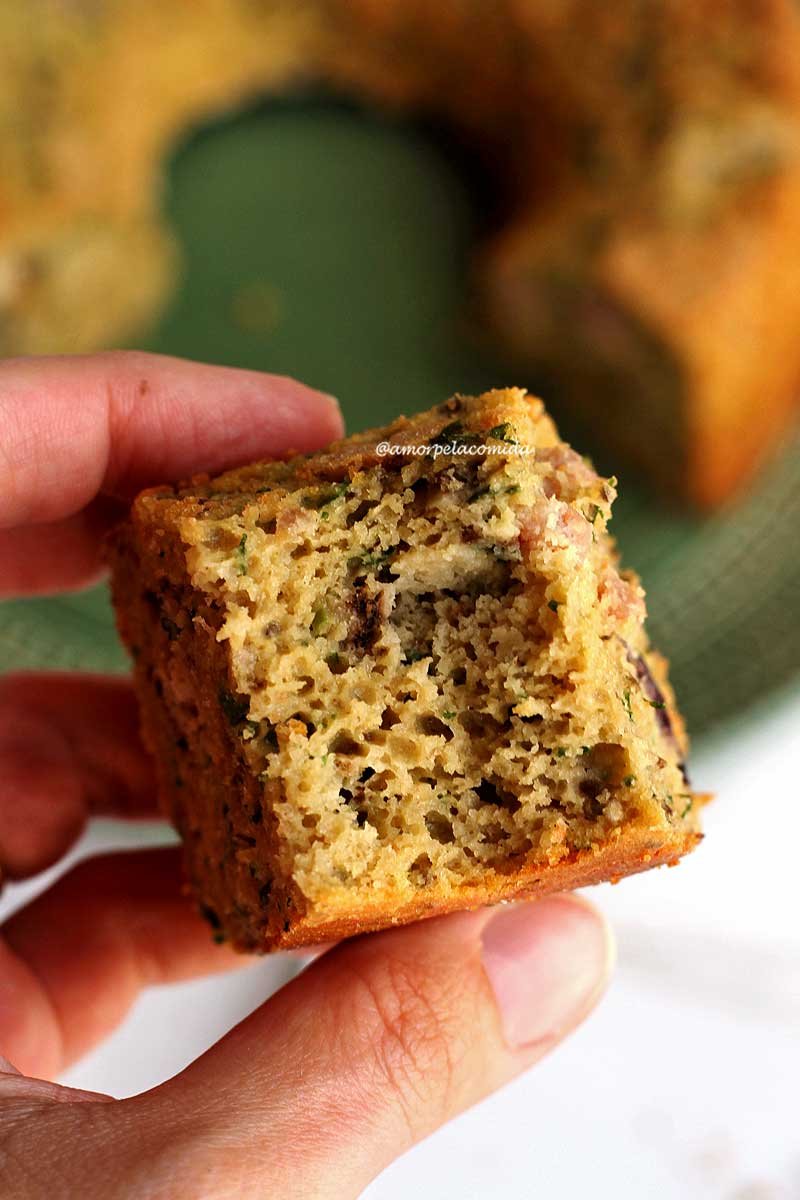 Bitten piece of savory sweet potato cake with a hand holding the piece