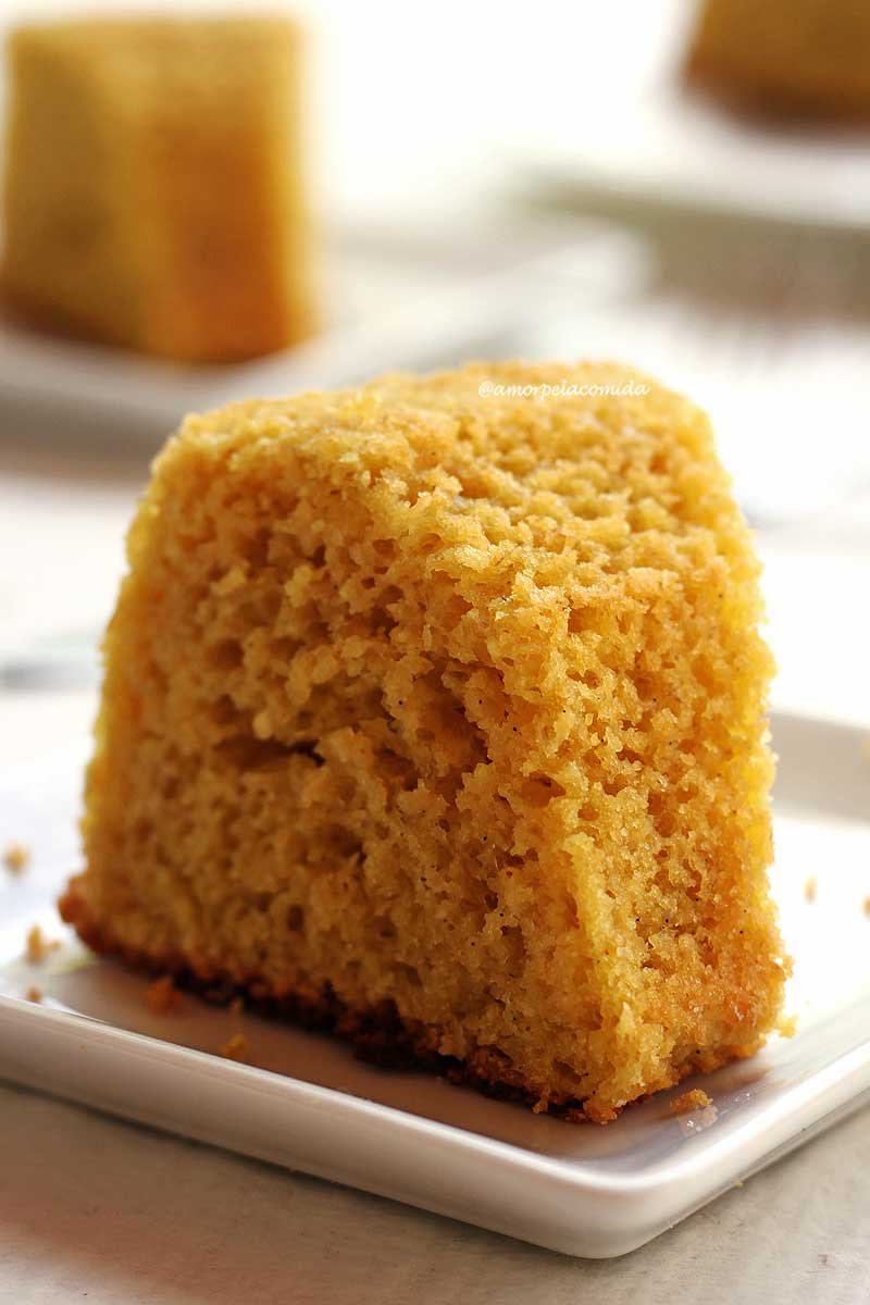 Fatia de bolo de coco sobre prato quadrado branco em uma mesa branca