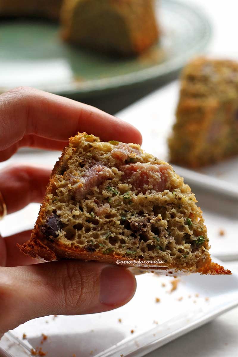 Hand holding piece of savory sweet potato cake on white table