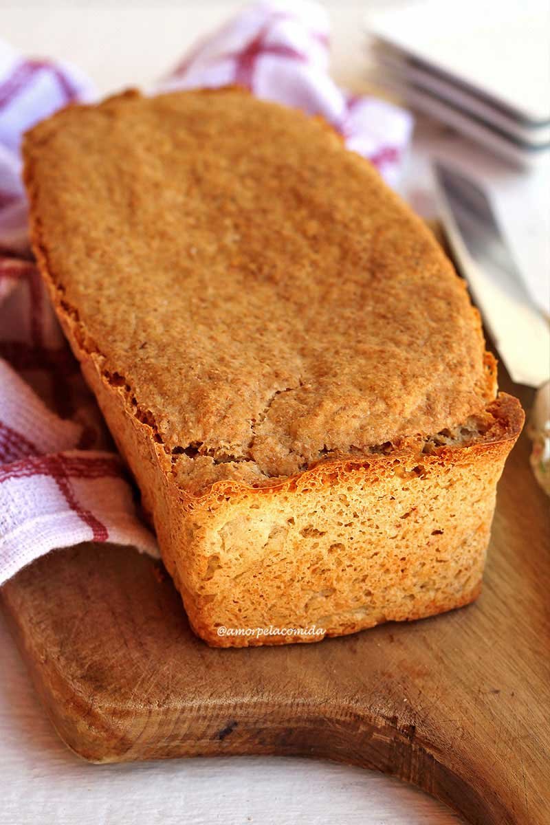 Pão de forma sobre tábua de madeira em uma mesa branca