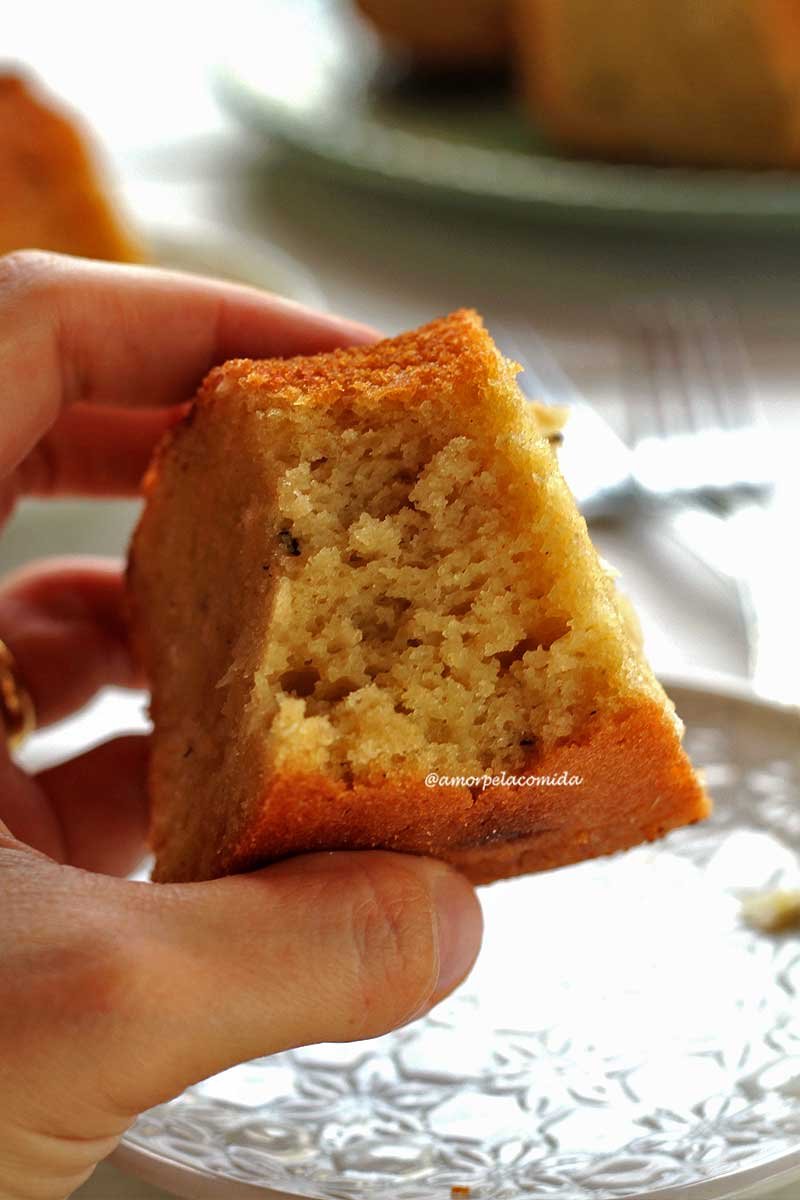 Mão segurando pedaço de bolo de aipim mordido