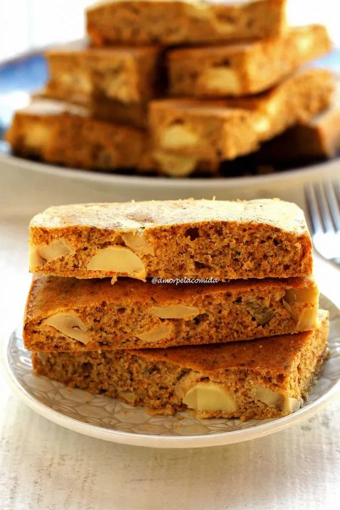 Três pedaços de torta salgada sobrepostos em prato redondo branco