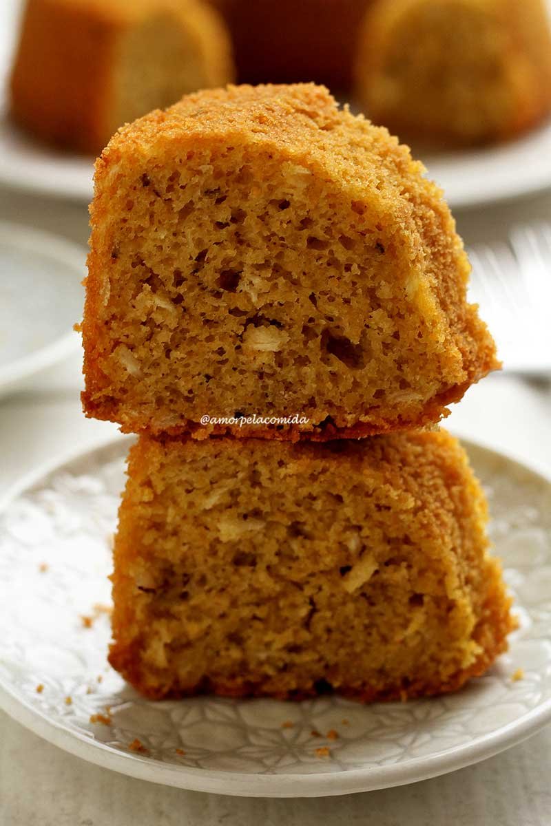 Duas fatias de bolo de fubá sobrepostas sobre prato branco