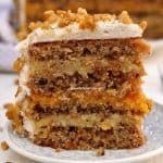 Fatia de bolo recheado com 3 camadas, duas de creme com nozes e a do meio com damasco