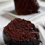 Duas fatias de bolo de chocolate com cobertura de chocolate sobre prato branco