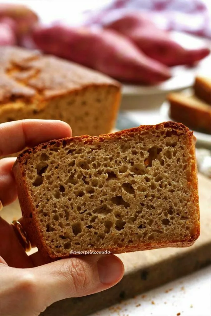 Hand holding slice of sweet potato bread