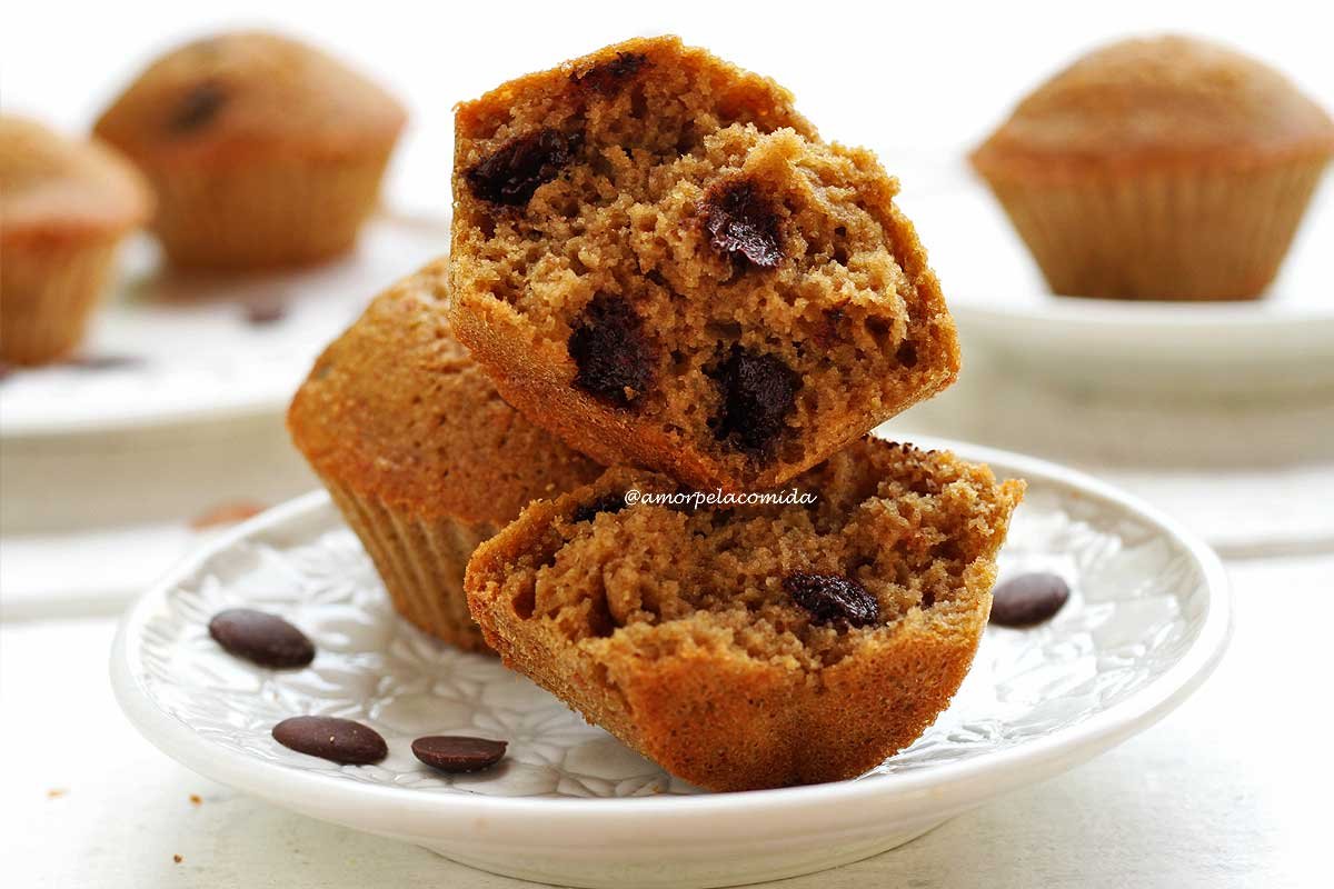 Bolo de baunilha com gotas de chocolate partido empilhado sobre a outro bolinho em um prato branco redondo em mesa branca