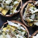 Vários cogumelos portobello recheados com queijo, cebola e sementes de girassol