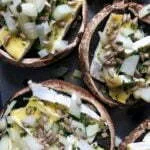 Vários cogumelos portobello recheados com queijo, cebola e sementes de girassol
