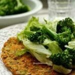 Pumpkin and onion pancake on a round white plate accompanied by American lettuce and broccoli