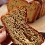 Mão segurando fatia de pão de batata que deu errado, ele afundou no centro e perdeu a estrutura