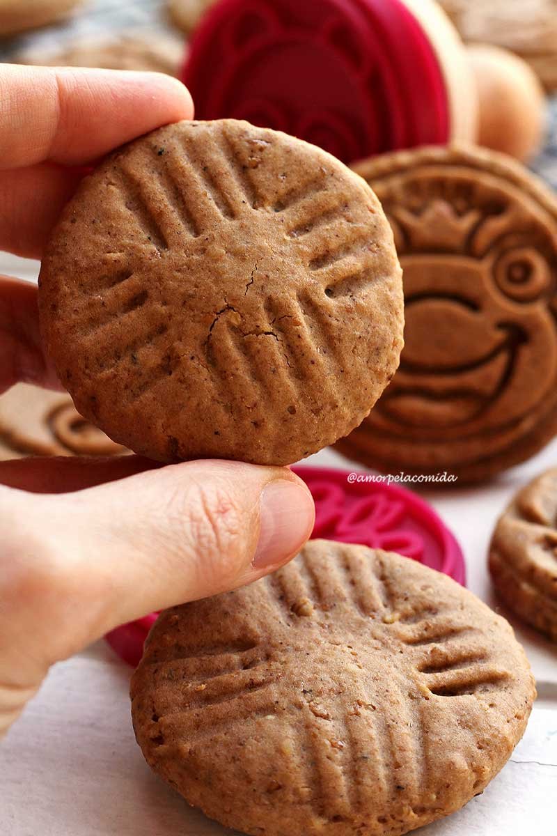 Hand holding round cookie on background more cookies