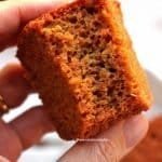 Mão segurando pedaço de bolo de beterraba mordido mostrando bem como o bolo é aerado