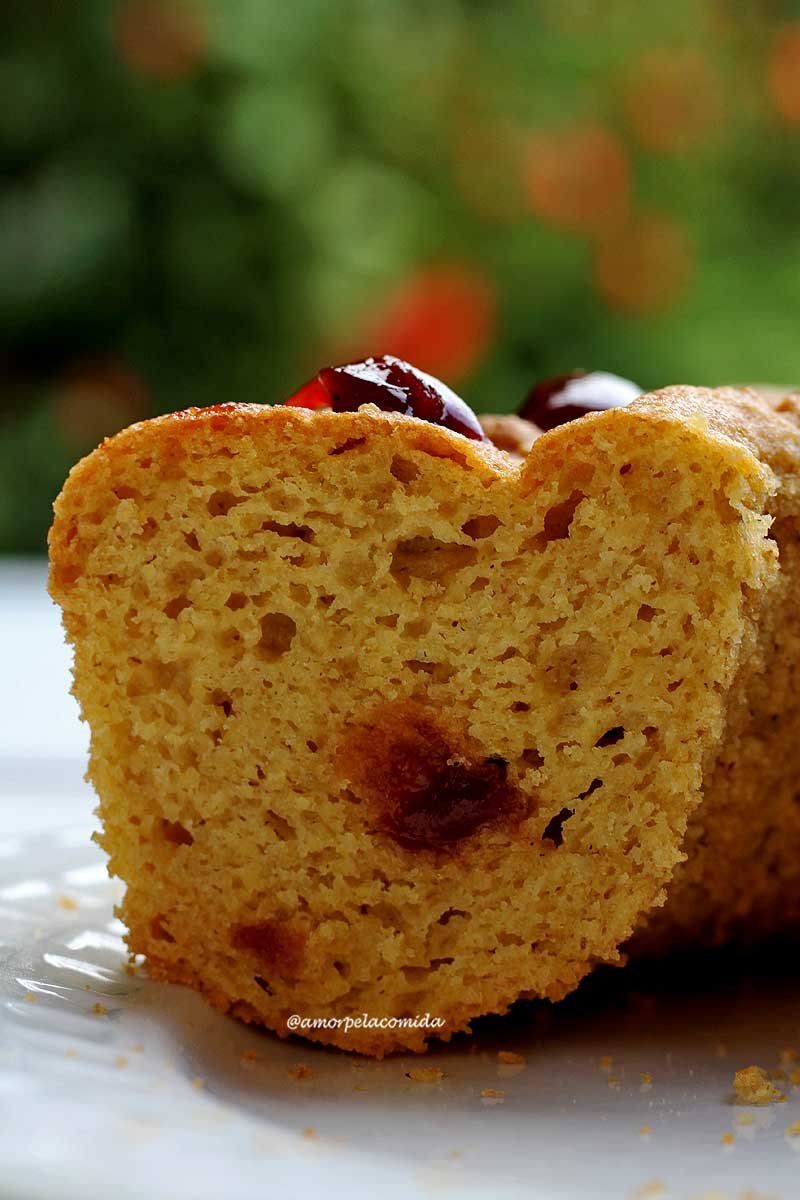 Bolo de fubá com goiabada cortado mostrando as características do bolo, ele tem bolhas de ar na estrutura e pedaços de goiabada no meio e em cima