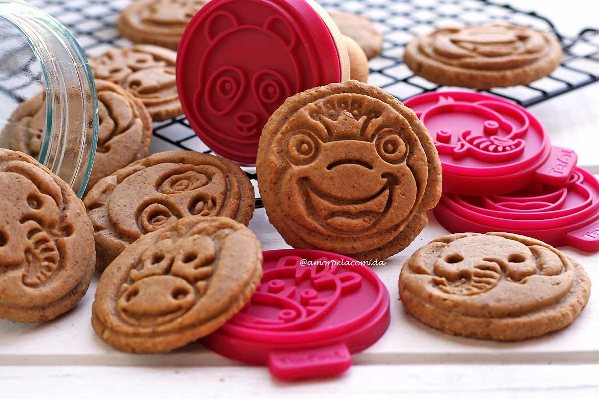 Several cookies spread out on a white table, some resting on a black grid