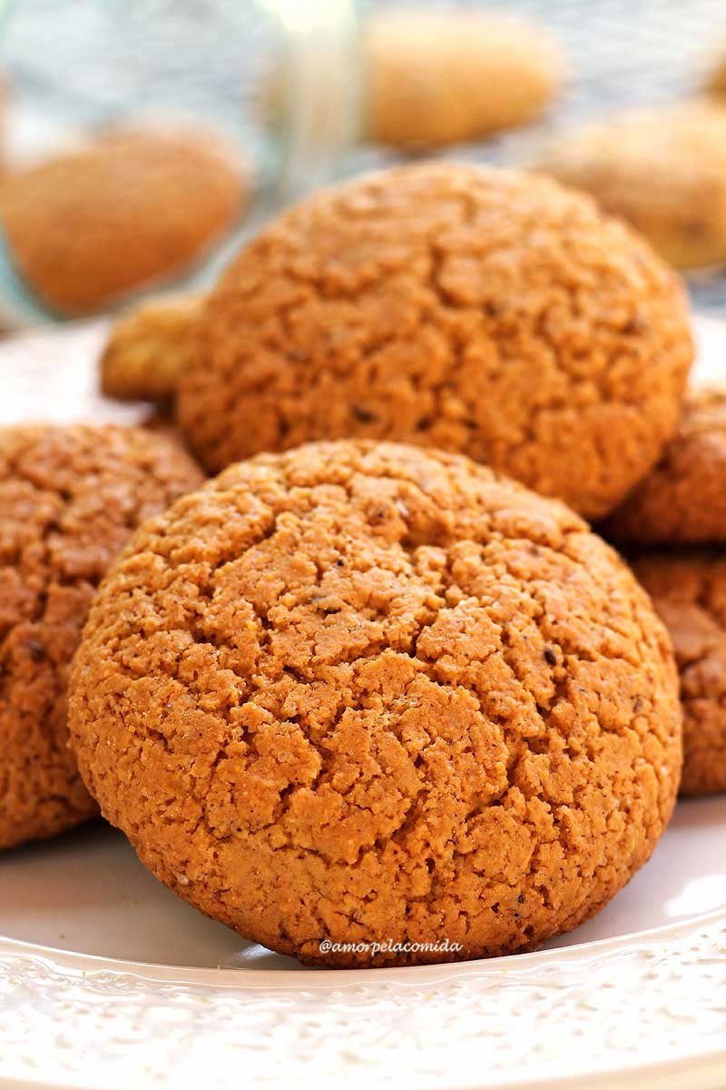 Several cornbreads piled up on a round white plate, in the background a glass lying down with more cornbreads inside, out of focus