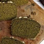 Três fatias de pão sobre tábua de madeira em uma mesa branca