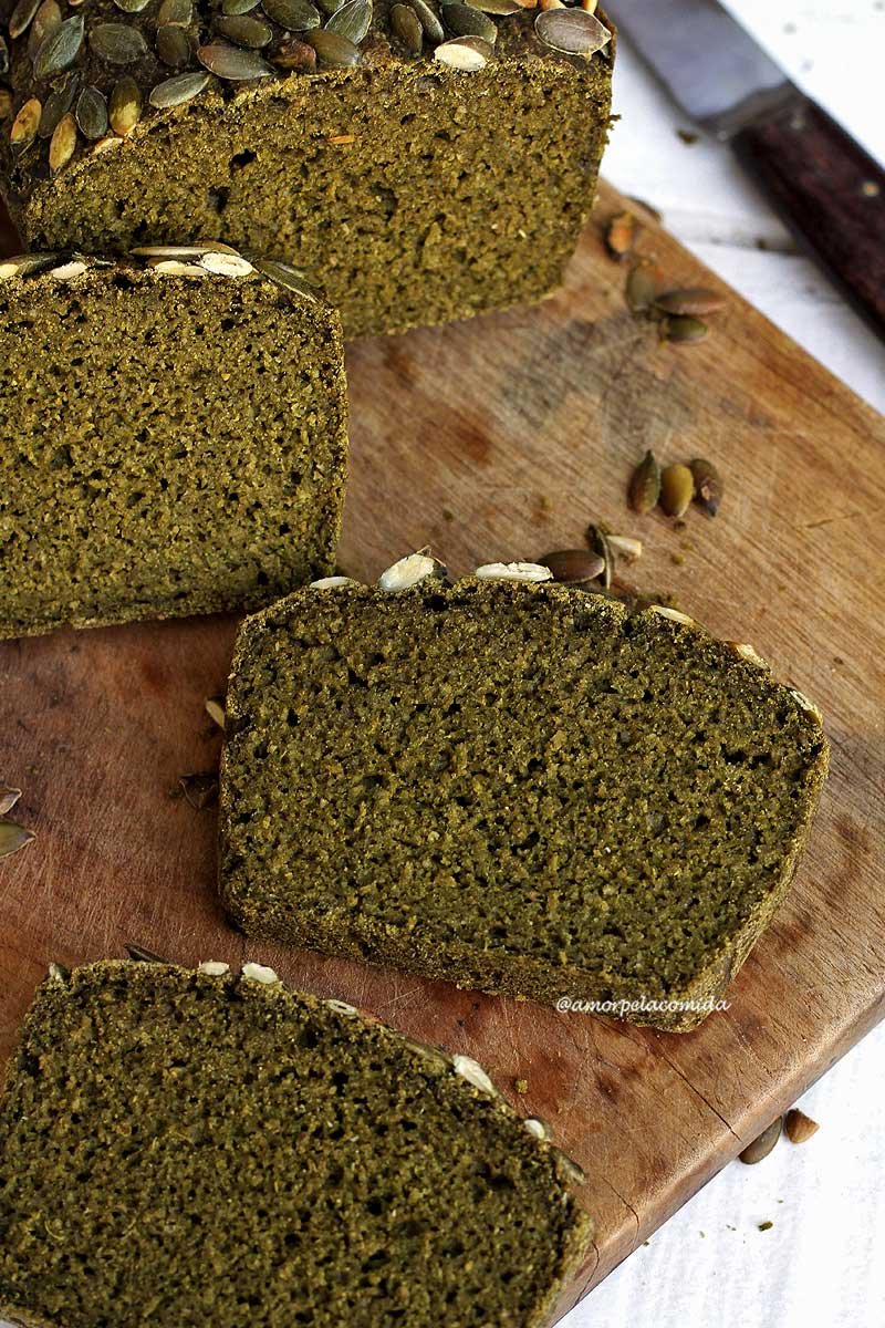 Três fatias de pão sobre tábua de madeira em uma mesa branca