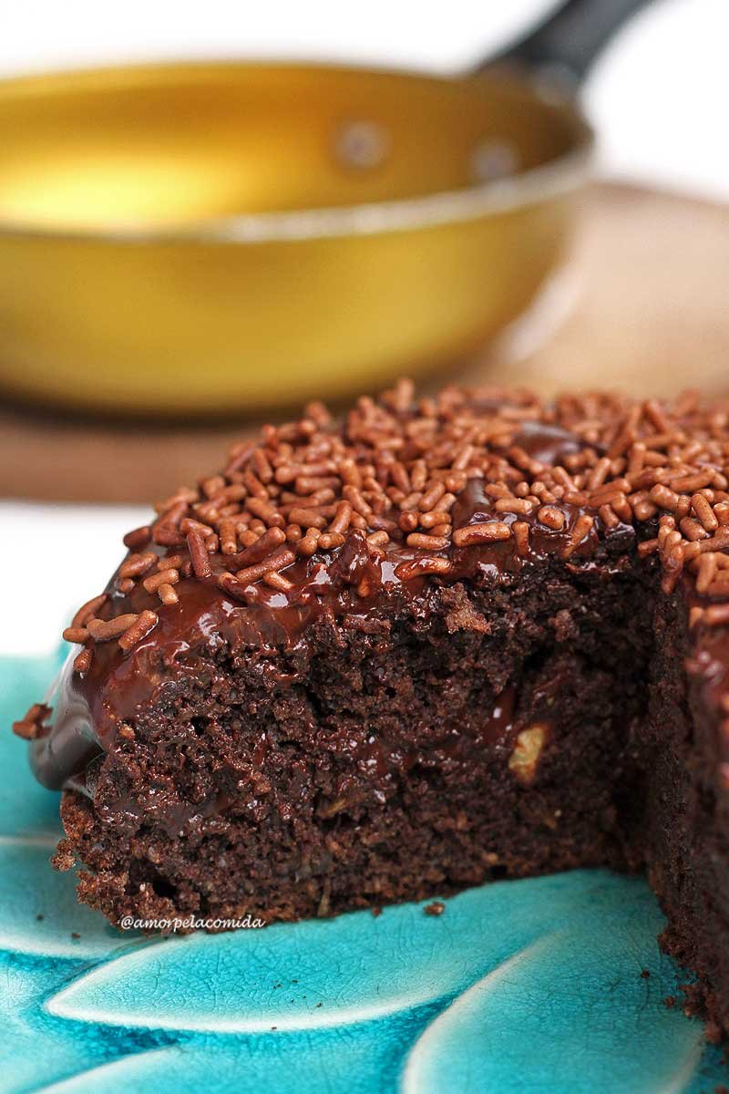 Bolo de chocolate redondo pequeno com 1/4 cortado mostrando a textura aerada interna