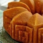 Bolo redondo com furo no meio assado em uma forma com padrões geométricos, lembrando arte deco