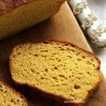 fatia de pão caseiro sobre tábua de madeira em uma mesa branca