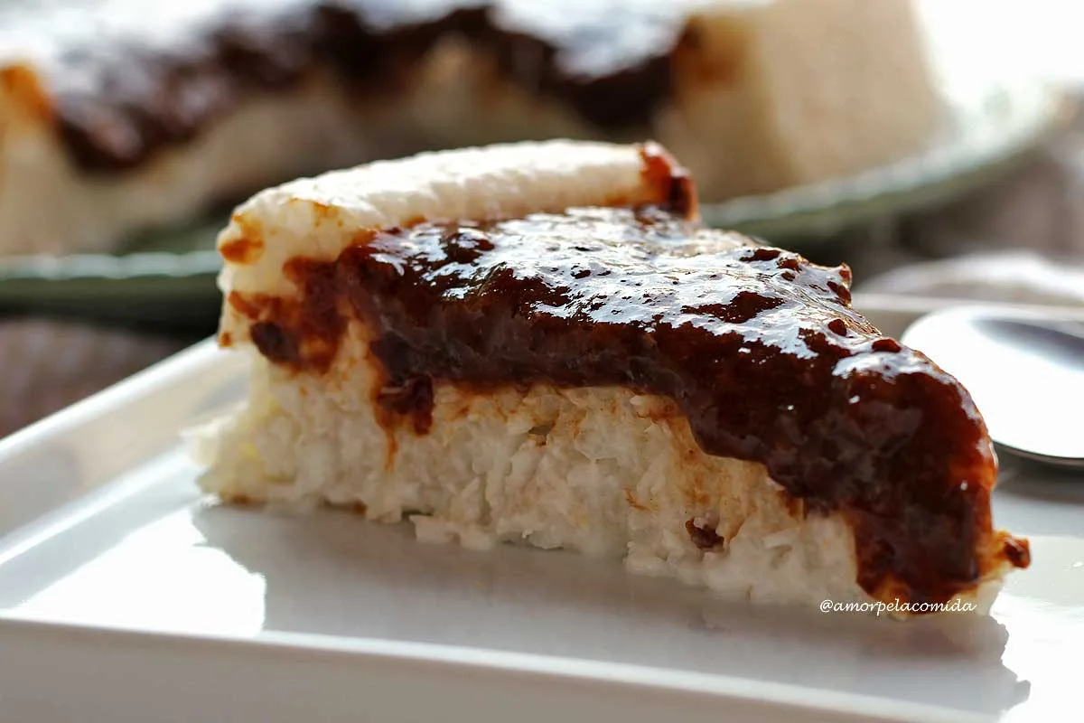 Fatia de bolo de tapioca com coco com calda de ameixa preta