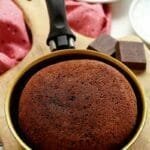 Frigideira dourada com cabo preto com bolo de chocolate dentro