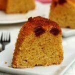 Fatia de bolo com pedacinhos de goiabada sobre prato quadrado branco pequeno