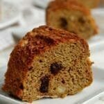 Três fatias de bolo alinhadas em uma mesa branca, cada uma está em um prato quadrado pequeno