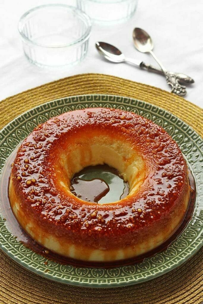 Pudim de tapioca sobre prato verde, o topo do pudim é caramelizado com bolinha de tapioca granulada