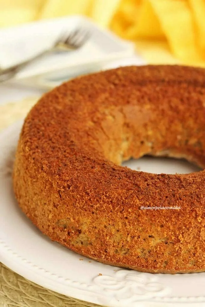 Gâteau rond avec trou au milieu sur une assiette blanche, en arrière-plan petites assiettes carrées