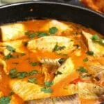 Panela preta grande com peixe em molho cremoso a base de leite de coco, dendê, tomate, cebola e pimentão