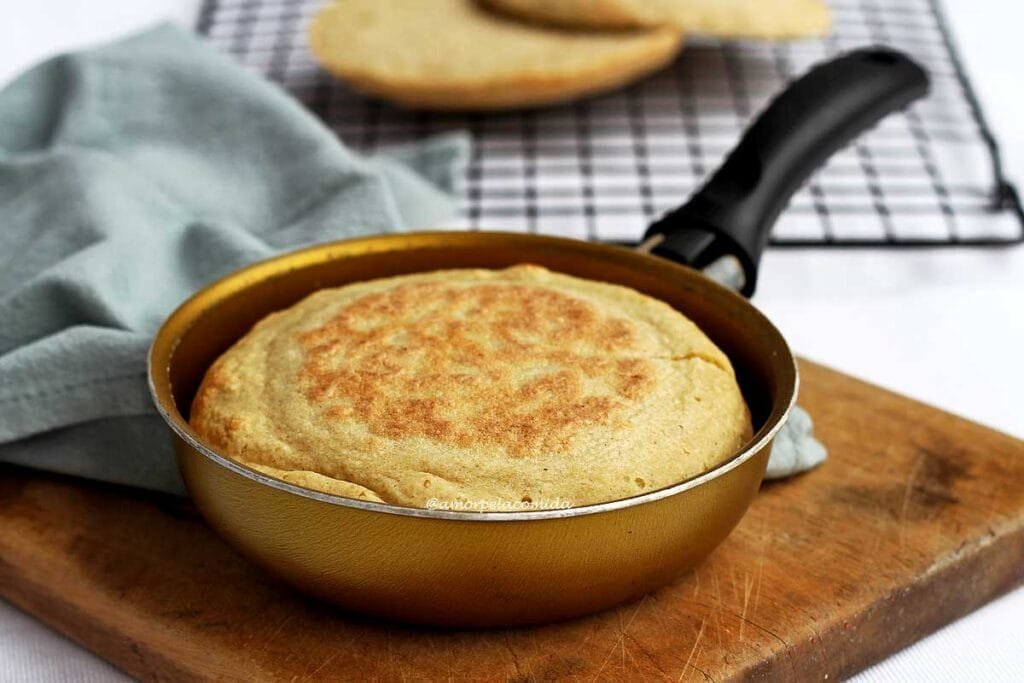 Frigideira redonda dourada com cabo preto com pão dentro