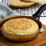Frigideira redonda dourada com cabo preto com pão dentro