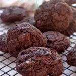 Various chocolate chip cookies piled up on the railing of cookies