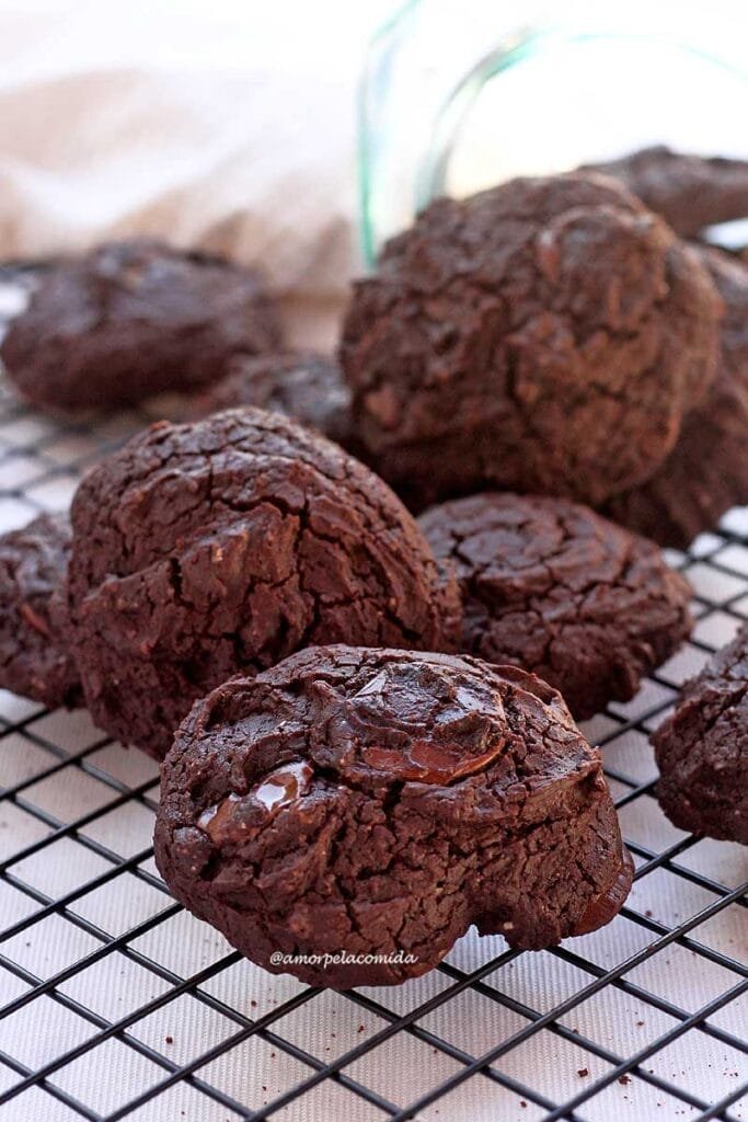 Vários biscoitos de chocolate amontoados sobre grade de biscoitos